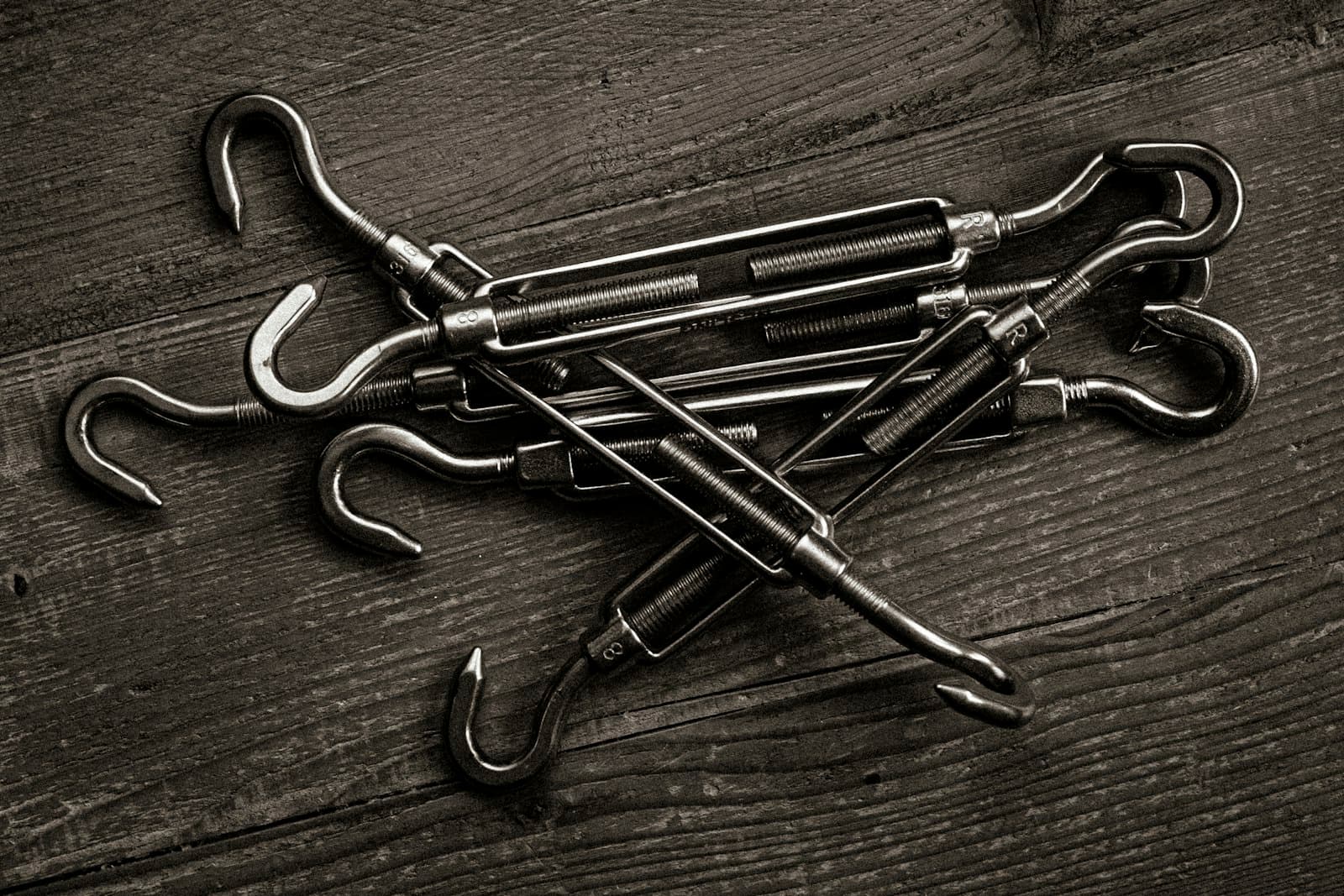 Metal turnbuckles with hooks on a wooden surface