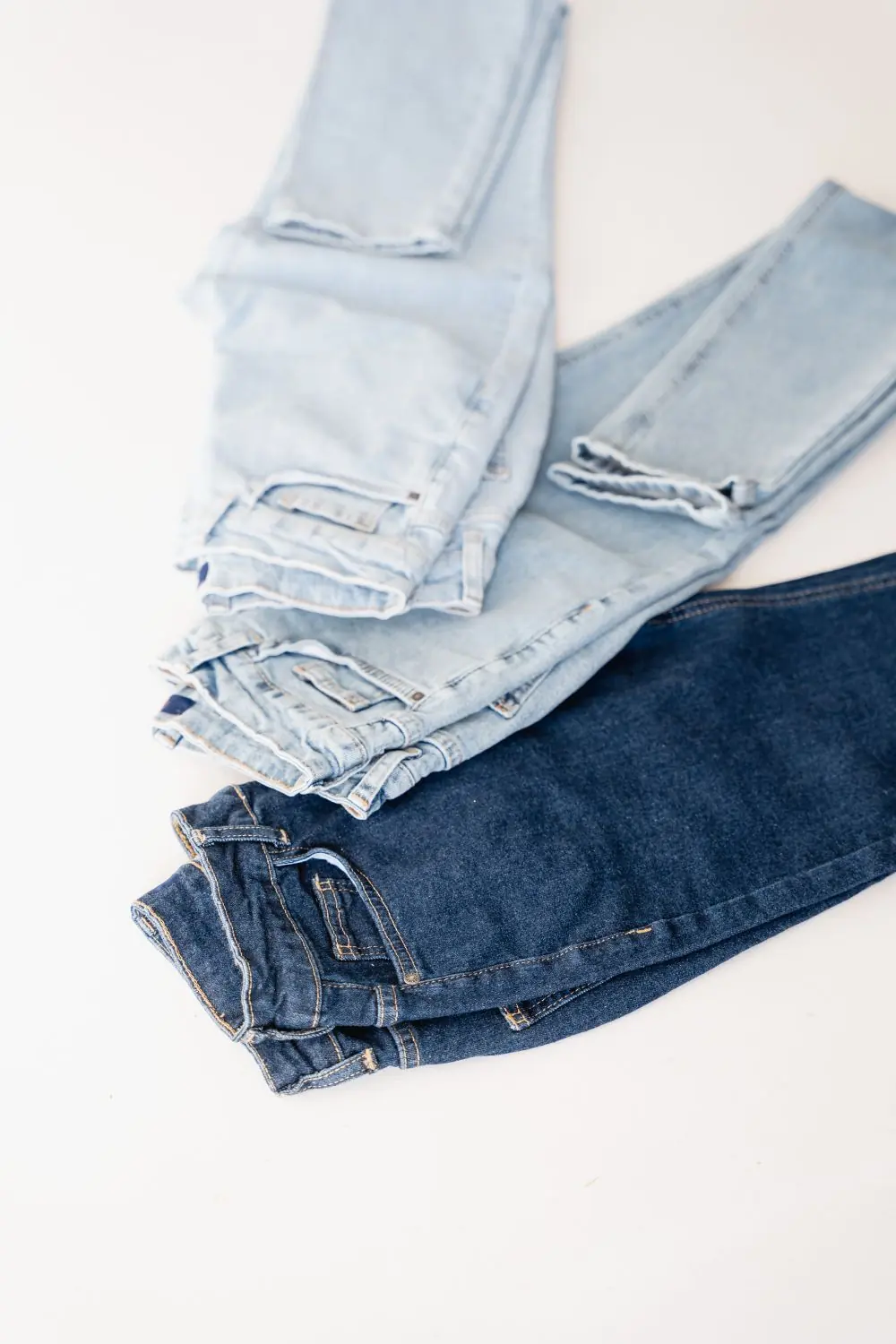 Reference photo 5: jeans in light and dark washes laid flat — jeans we manufacture and export in bulk to South Africa