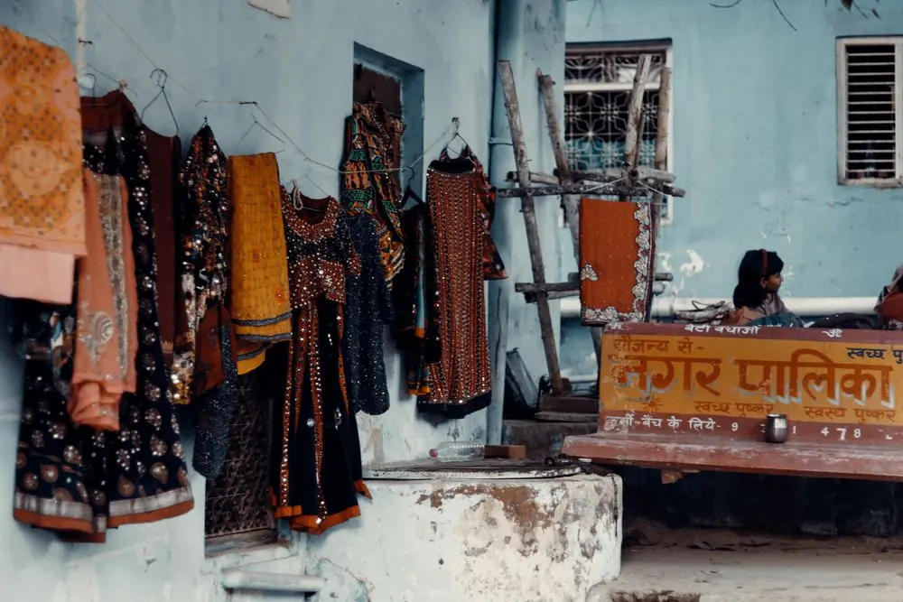Reference photo 2: colourful Indian garments hanging outside a shop — kurtis we manufacture and export in bulk