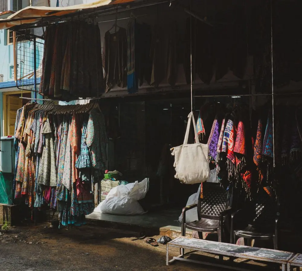 Reference photo 3: clothes hanging at a market stall in Rajasthan — kurtis we manufacture and export in bulk
