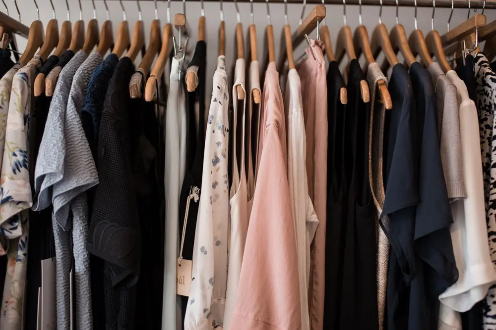Reference photo 2: women's dresses and tops on wooden hangers in a boutique — ladies tops & dresses we manufacture and export in bulk to France