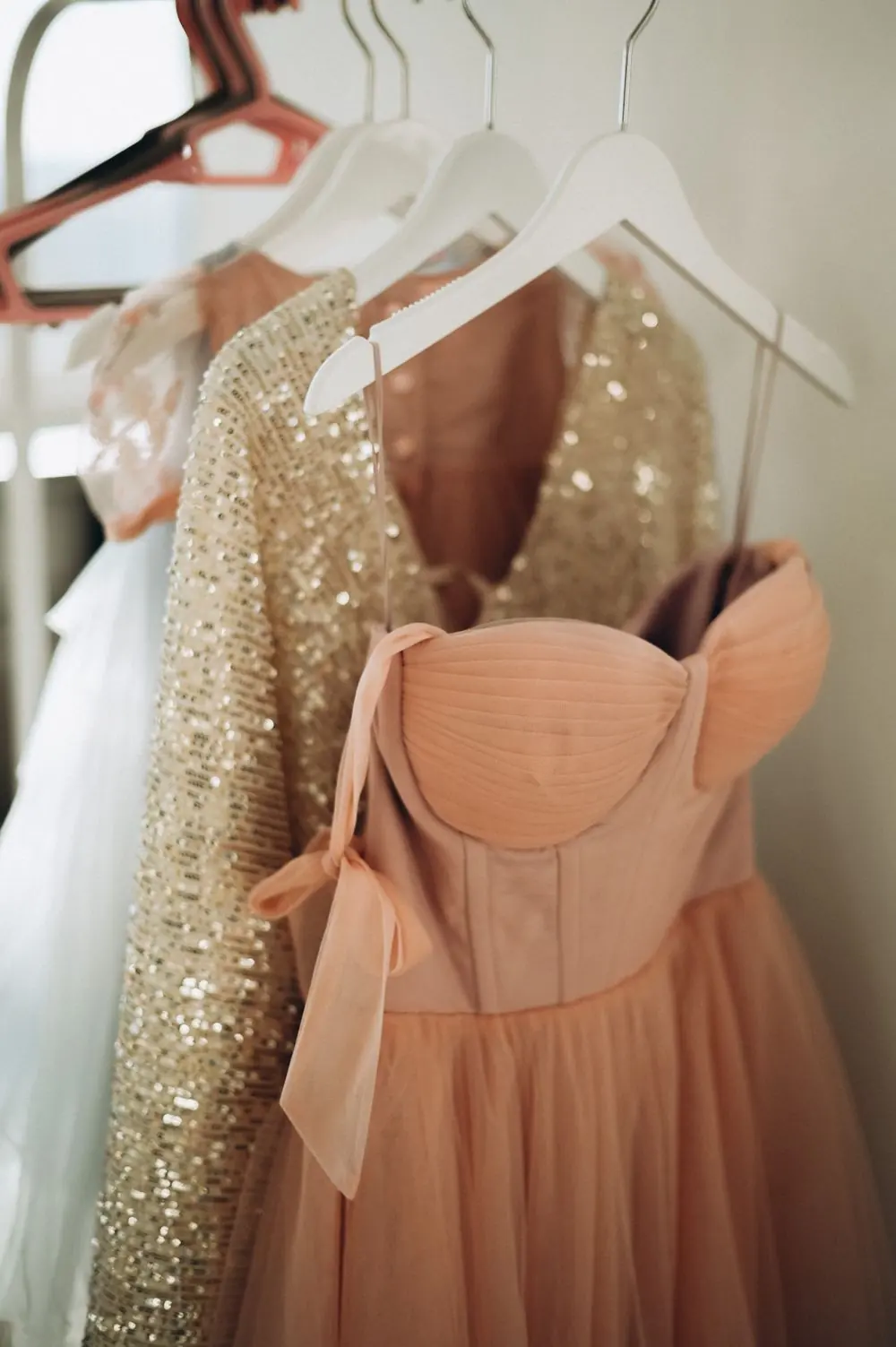 Reference photo 3: peach and sequin dresses on hangers — ladies tops & dresses we manufacture and export in bulk to France