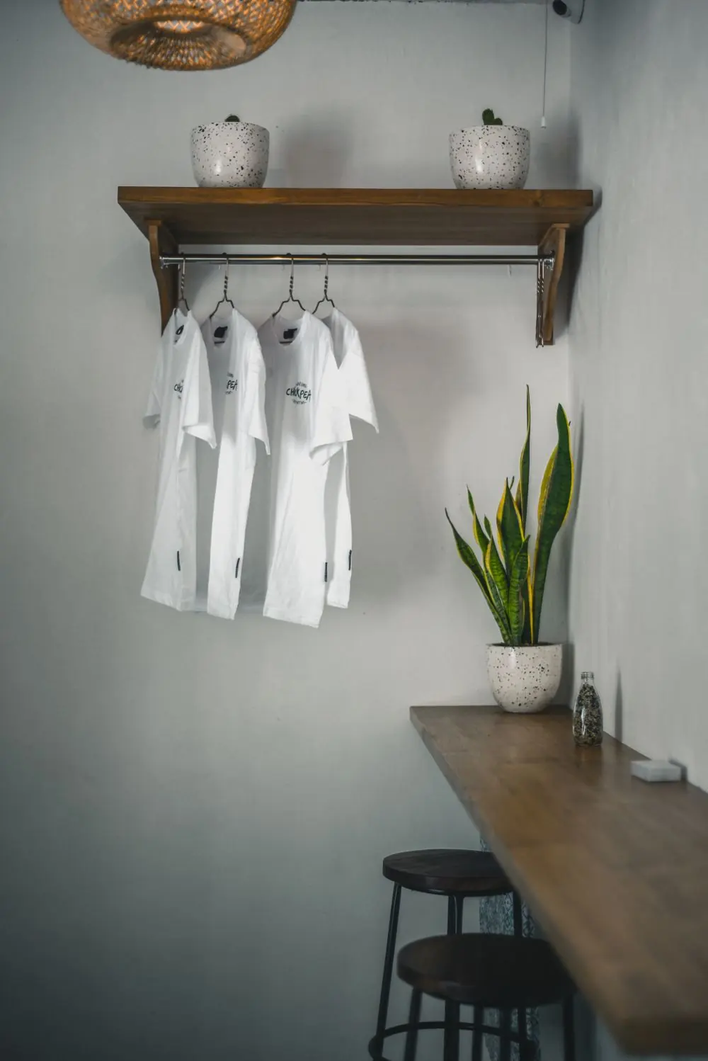 Reference photo 3: white T-shirts hanging on a wall rail — t-shirts we manufacture and export in bulk