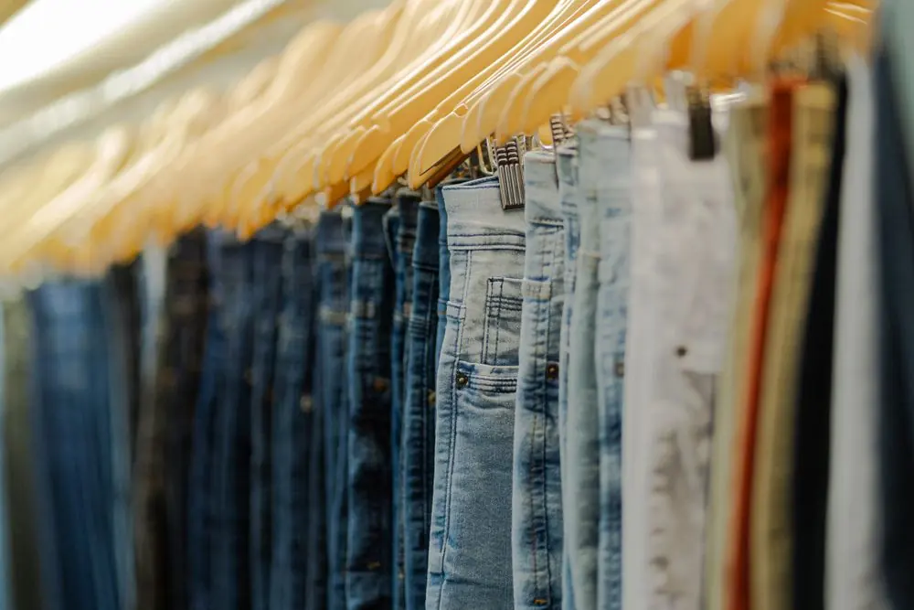 Reference photo 3: rows of trousers on wooden hangers — trousers & cargo pants we manufacture and export in bulk to United States