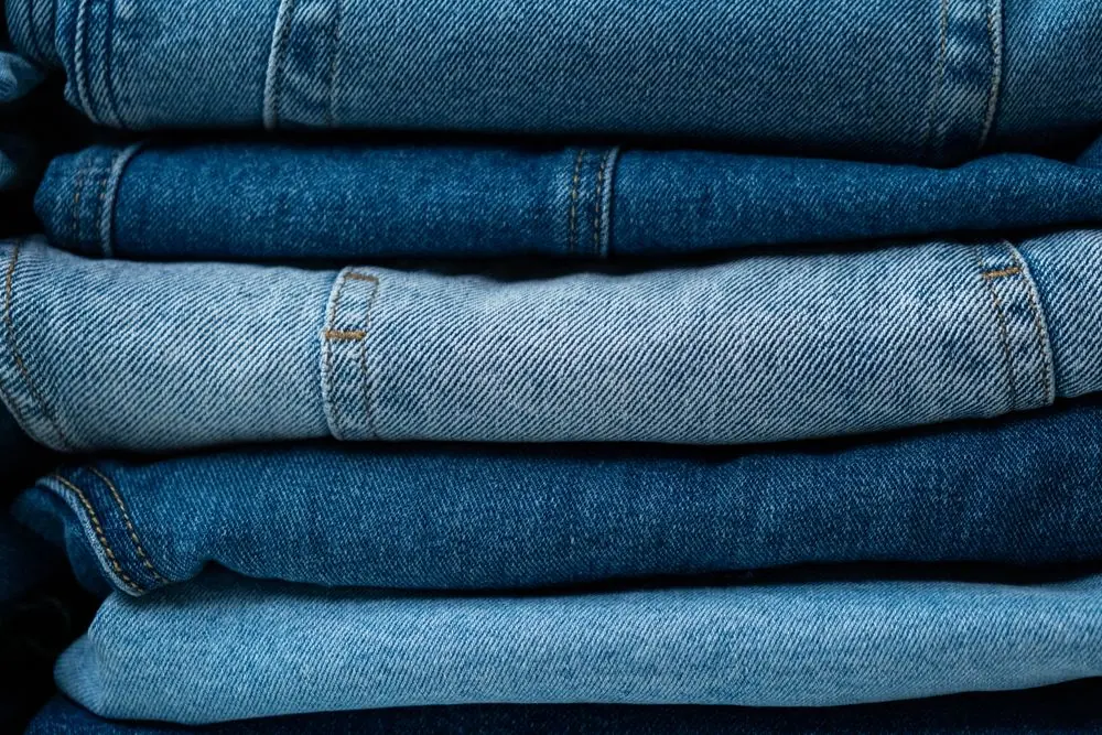 Reference photo 5: stack of folded trousers in indigo shades — trousers & cargo pants we manufacture and export in bulk to United States